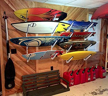 The StoreYourBoard wall rack on display in a garage and mounted to the wall with wakeboards on it.