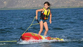 Airhead EZ Wake being towed in the water with a child riding it.