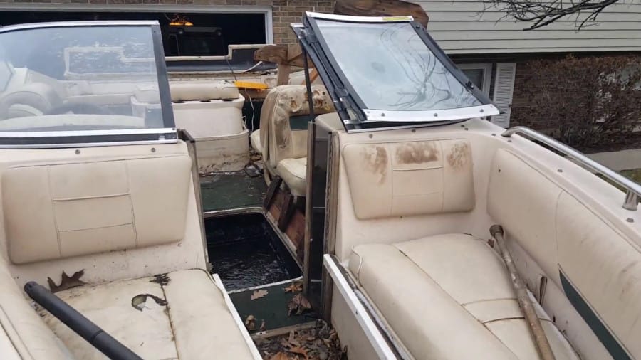 An ugly boat that has been uncovered for many years with lots of rot and mold.