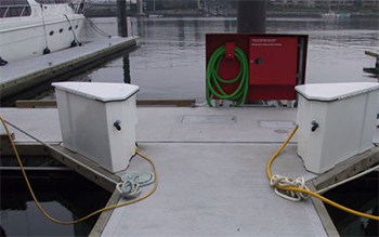 A marina dock with two lockable storage boxes for the slip owners to use.