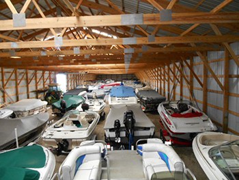 Many boats stored in a large warehouse for the off-season.
