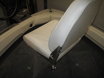 A pedistal swivel seat mounted to a wood platform that was cut out to fit into the bow of a bowrider boat.