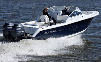 A dual console boat with dual outboards out in the water on a nice day showing that it also has an open bow layout.
