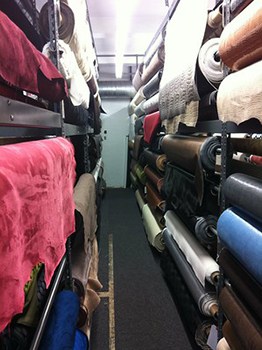 A fabric supply store with large rolls of marine vinyl on racks.