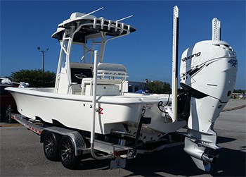 A center console boat sitting on it's trailer showing that it also has a open bow configuration, but is more for walking than sitting.