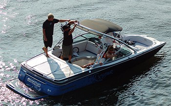 Looking down from above on a wake boat in the water showing that it has an open bow, but with less room.