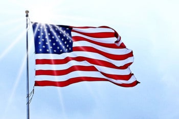 United States flag waving in the wind on a bright sunny day.