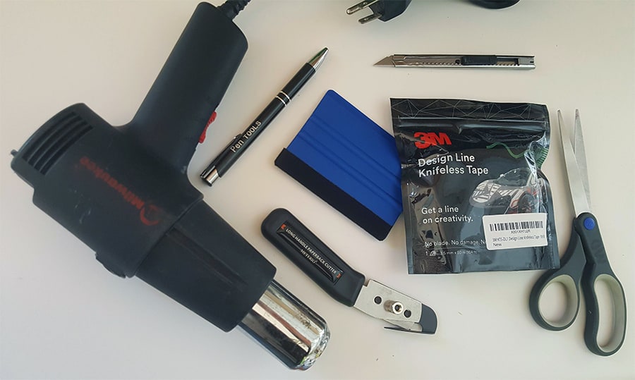 A vinyl wrapping tool kit including a heat gun, needle pen, razor knife, squegee, sizzors, knifeless tape, and a pull vinyl cutter.
